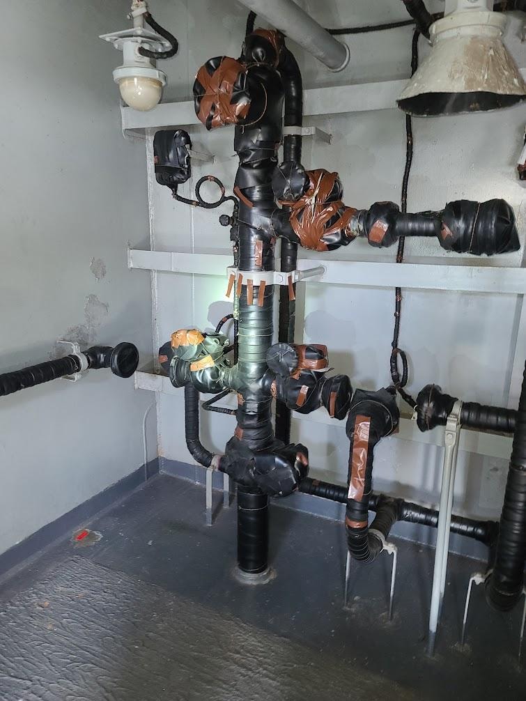 Shipboard valve system wrapped in strip rubber, ready for blast and paint