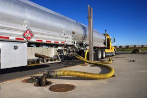 A yellow hose is connected to the back of a truck.