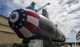 A large american flag painted submarine on display.